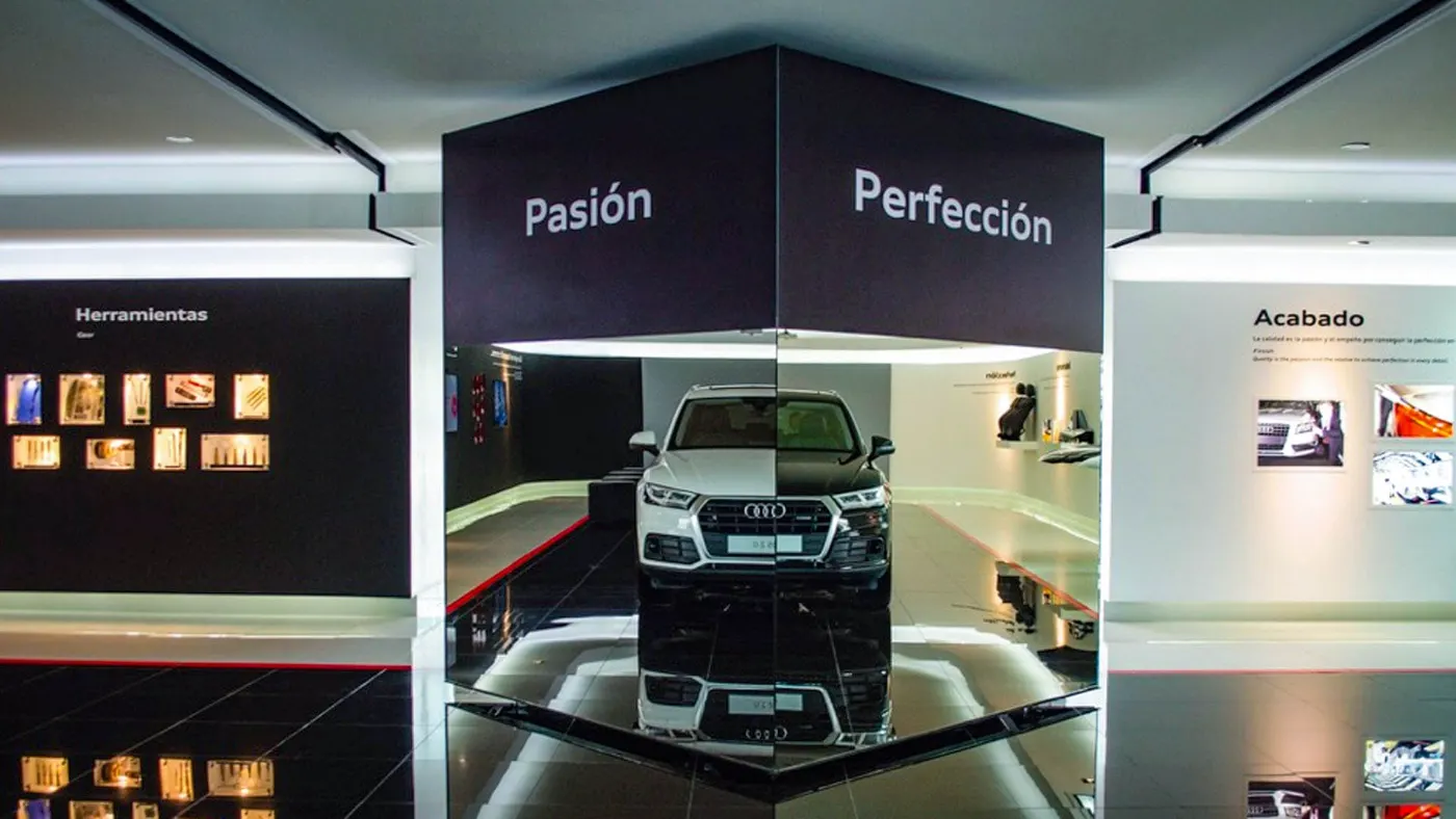 Showroom de Audi con el coche sobre plataforma iluminada